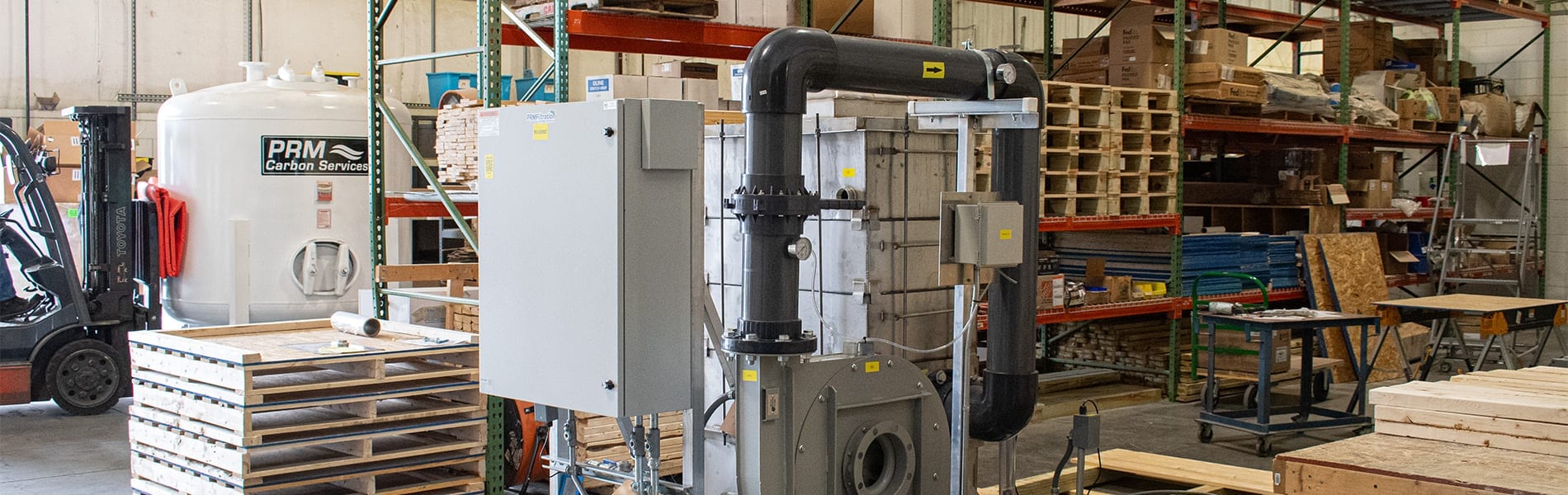 Product Recovery Management industrial manufacturing facility with air stripper water treatment equipment and GAC tanks in warehouse setting
