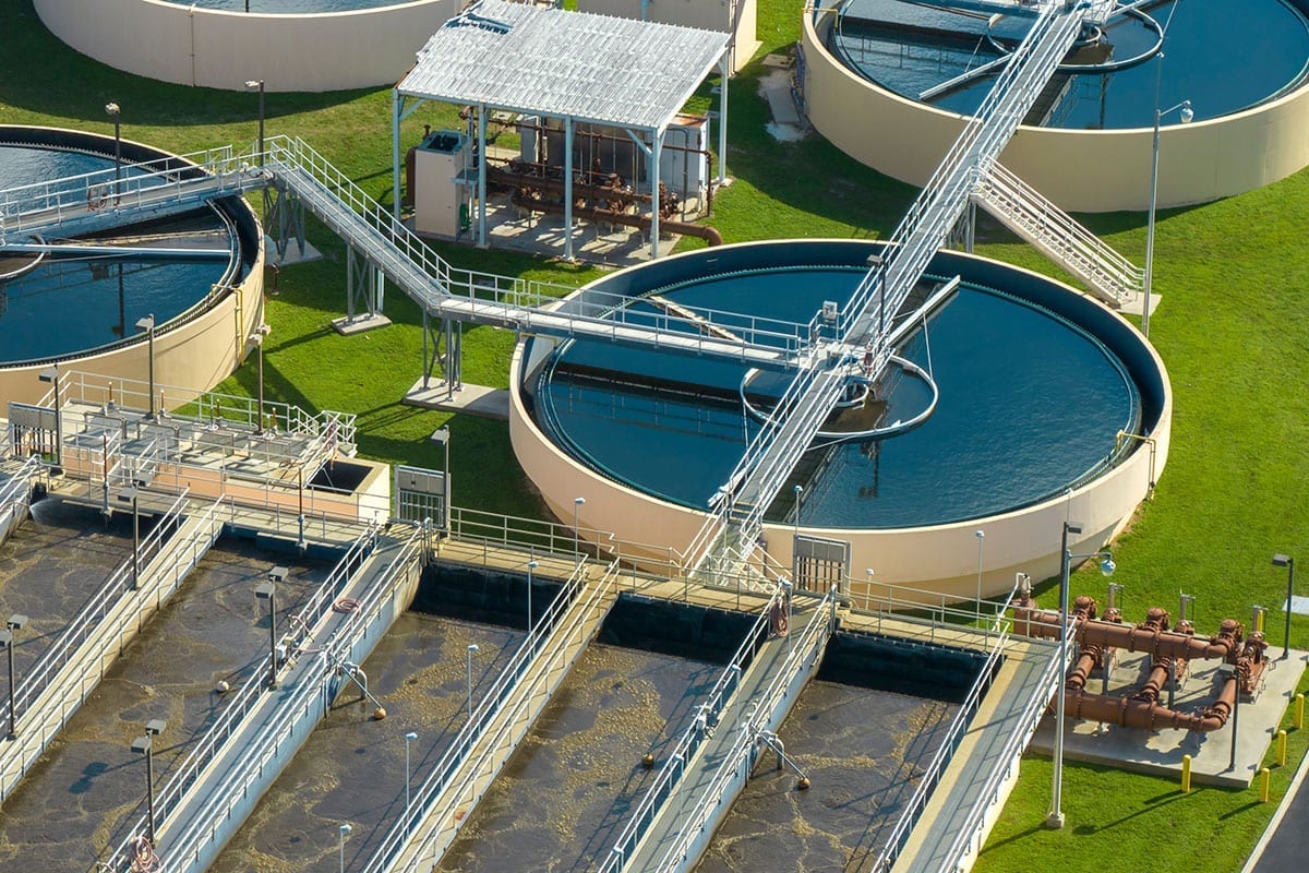 Aerial view of a municipal water treatment plant with circular clarifiers and rectangular basins